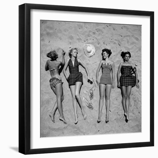 Four Models Showing Off the Latest Bathing Suit Fashions While Lying on a Sandy Florida Beach-Nina Leen-Framed Photographic Print