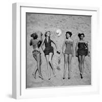 Four Models Showing Off the Latest Bathing Suit Fashions While Lying on a Sandy Florida Beach-Nina Leen-Framed Photographic Print