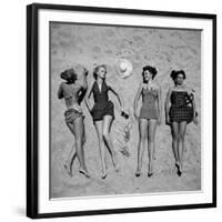 Four Models Showing Off the Latest Bathing Suit Fashions While Lying on a Sandy Florida Beach-Nina Leen-Framed Photographic Print