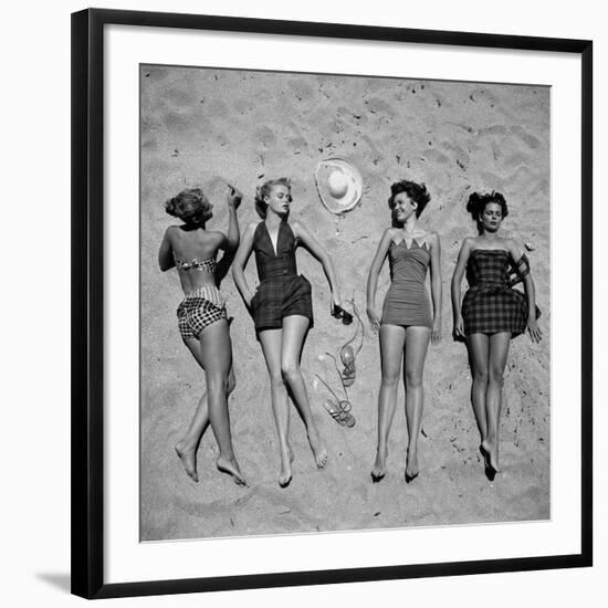 Four Models Showing Off the Latest Bathing Suit Fashions While Lying on a Sandy Florida Beach-Nina Leen-Framed Photographic Print