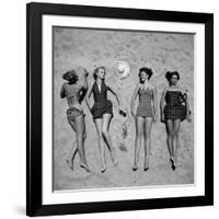 Four Models Showing Off the Latest Bathing Suit Fashions While Lying on a Sandy Florida Beach-Nina Leen-Framed Photographic Print