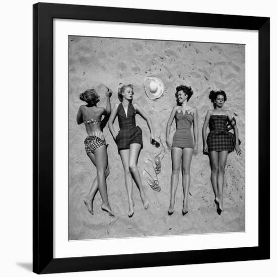 Four Models Showing Off the Latest Bathing Suit Fashions While Lying on a Sandy Florida Beach-Nina Leen-Framed Photographic Print