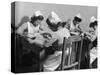 Four Young British Student Nurses Making Notes Together from Medical Textbooks-null-Stretched Canvas