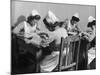 Four Young British Student Nurses Making Notes Together from Medical Textbooks-null-Mounted Photographic Print