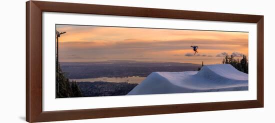 Freestyle skier doing a trick off a jump above city at sunset, Canada, North America-Tyler Lillico-Framed Photographic Print