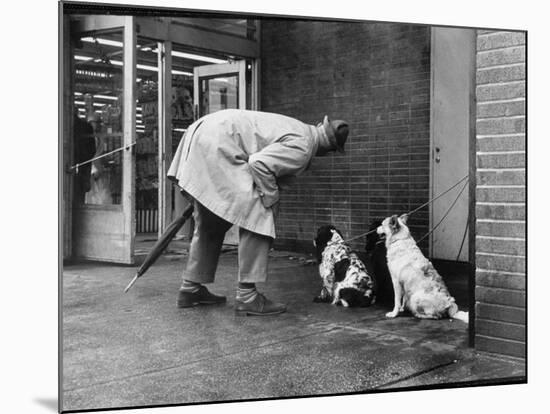 French Actor Jacques Tati Talking to a Couple of Dogs-Yale Joel-Mounted Premium Photographic Print