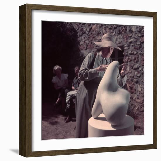 French Sculptor Jean Arp, Alone, Polishing Abstract Sculpture in His Garden Near Paris-Gjon Mili-Framed Premium Photographic Print