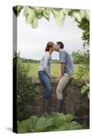 Full Length Side View of a Couple Kissing on Countryside Wall against Landscape-Nosnibor137-Stretched Canvas