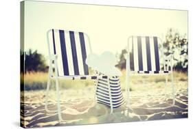 Furniture and Summer Holidays Concept - Two Beach Lounges with Beach Bag and White Hat on the Beach-dolgachov-Stretched Canvas