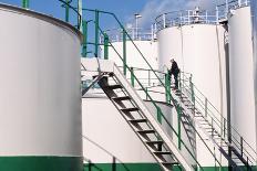 Worker Inspecting An Oil Storage Tank-Geoff Tompkinson-Photographic Print