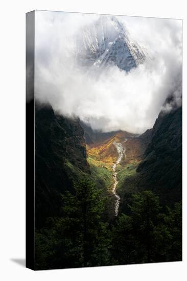 Giant mountain emerging through the clouds in the Himalayas, Nepal on the way to Everest Base Camp-David Chang-Stretched Canvas