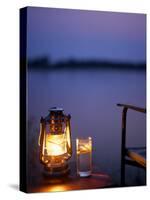Gin and Tonic by the Light of Hurricane Lamp, Looking Out over the Zambezi River, Zambia-John Warburton-lee-Stretched Canvas