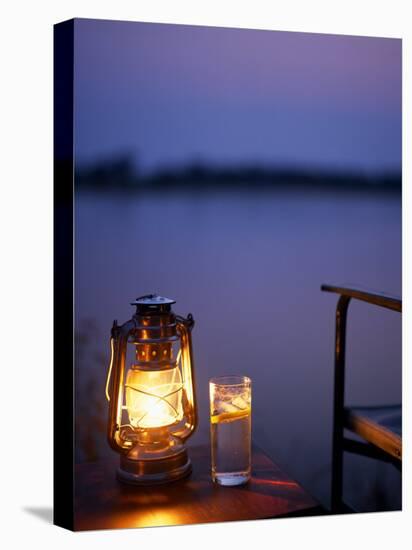 Gin and Tonic by the Light of Hurricane Lamp, Looking Out over the Zambezi River, Zambia-John Warburton-lee-Stretched Canvas