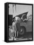 Girl Attendant Looking For Battery For Customer-Allan Grant-Framed Stretched Canvas