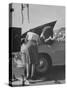 Girl Attendant Looking For Battery For Customer-Allan Grant-Stretched Canvas