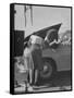 Girl Attendant Looking For Battery For Customer-Allan Grant-Framed Stretched Canvas