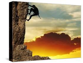 Girl Climbing On The Rock On Sunset Background-Andrushko Galyna-Stretched Canvas