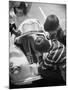 Girl Demurely Adjusting Her Hair While Willing Volunteers Repair Jammed Front Wheels of Her Car-Nina Leen-Mounted Photographic Print