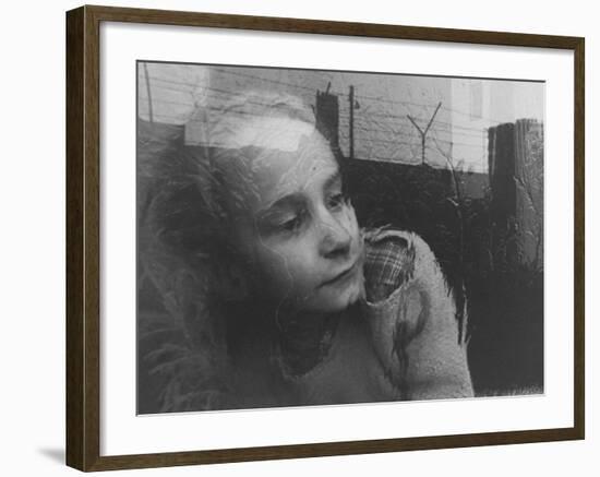 Girl Gazing Pensively Through Pane of Her Apartment Window, Grimly Reflects Image of Berlin Wall-Paul Schutzer-Framed Photographic Print