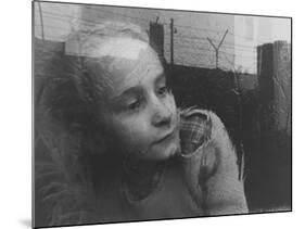 Girl Gazing Pensively Through Pane of Her Apartment Window, Grimly Reflects Image of Berlin Wall-Paul Schutzer-Mounted Photographic Print