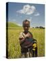 Girl Holding Yellow Meskel Flowers in a Fertile Green Wheat Field after the Rains-Gavin Hellier-Stretched Canvas