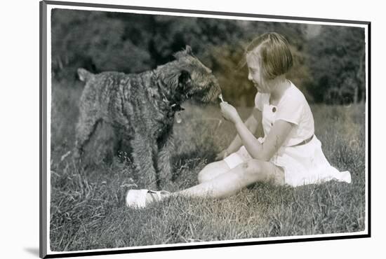 Girl Offering Her Dog a Lollipop-null-Mounted Photographic Print