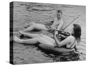 Girl Playing Violin For Boy as They Float on Inner Tube Sat Floating Party on the Apple River-Alfred Eisenstaedt-Stretched Canvas