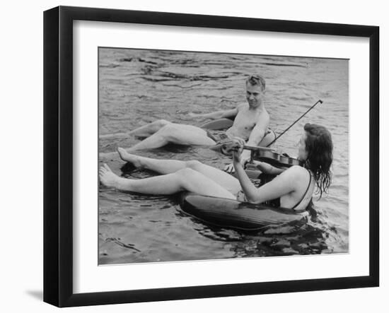 Girl Playing Violin For Boy as They Float on Inner Tube Sat Floating Party on the Apple River-Alfred Eisenstaedt-Framed Photographic Print