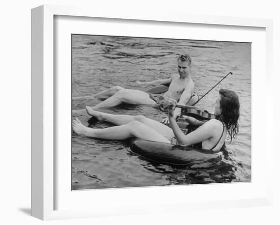 Girl Playing Violin For Boy as They Float on Inner Tube Sat Floating Party on the Apple River-Alfred Eisenstaedt-Framed Photographic Print