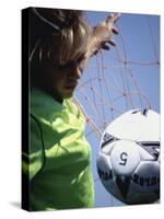 Girl Standing in a Goal Looking at a Soccer Ball-null-Stretched Canvas