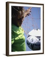 Girl Standing in a Goal Looking at a Soccer Ball-null-Framed Premium Photographic Print