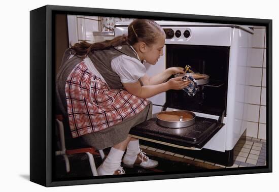 Girl Wearing Apron Removing Cakes from Oven-William P. Gottlieb-Framed Stretched Canvas