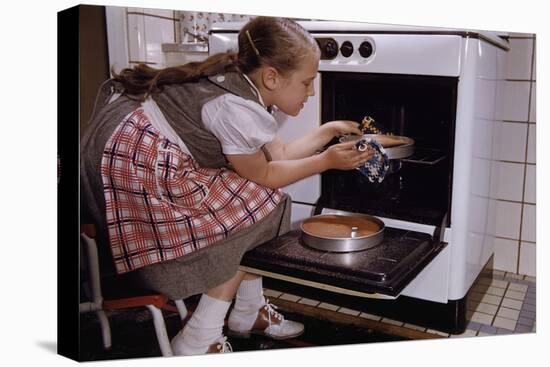 Girl Wearing Apron Removing Cakes from Oven-William P. Gottlieb-Stretched Canvas