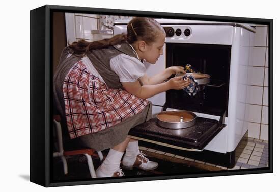 Girl Wearing Apron Removing Cakes from Oven-William P. Gottlieb-Framed Stretched Canvas