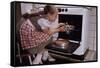 Girl Wearing Apron Removing Cakes from Oven-William P. Gottlieb-Framed Stretched Canvas