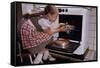 Girl Wearing Apron Removing Cakes from Oven-William P. Gottlieb-Framed Stretched Canvas