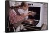 Girl Wearing Apron Removing Cakes from Oven-William P. Gottlieb-Framed Stretched Canvas