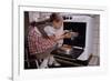 Girl Wearing Apron Removing Cakes from Oven-William P. Gottlieb-Framed Photographic Print