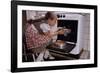 Girl Wearing Apron Removing Cakes from Oven-William P. Gottlieb-Framed Photographic Print