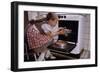 Girl Wearing Apron Removing Cakes from Oven-William P. Gottlieb-Framed Photographic Print