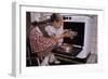 Girl Wearing Apron Removing Cakes from Oven-William P. Gottlieb-Framed Photographic Print