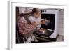 Girl Wearing Apron Removing Cakes from Oven-William P. Gottlieb-Framed Photographic Print