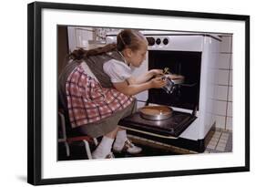 Girl Wearing Apron Removing Cakes from Oven-William P. Gottlieb-Framed Photographic Print