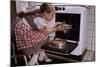 Girl Wearing Apron Removing Cakes from Oven-William P. Gottlieb-Mounted Photographic Print