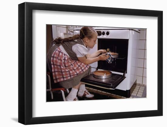 Girl Wearing Apron Removing Cakes from Oven-William P. Gottlieb-Framed Photographic Print