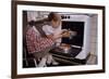 Girl Wearing Apron Removing Cakes from Oven-William P. Gottlieb-Framed Photographic Print