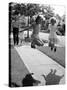 Girls on the street in neighborhood using rope to jump in tandem while man with toddler watches-Alfred Eisenstaedt-Stretched Canvas