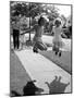 Girls on the street in neighborhood using rope to jump in tandem while man with toddler watches-Alfred Eisenstaedt-Mounted Photographic Print