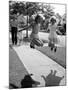 Girls on the street in neighborhood using rope to jump in tandem while man with toddler watches-Alfred Eisenstaedt-Mounted Photographic Print