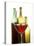 Glass of Red Wine in Front of Three Wine Bottles-Joerg Lehmann-Stretched Canvas